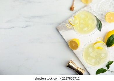 Delicious bee's knees cocktails and ingredients on white table, flat lay. Space for text