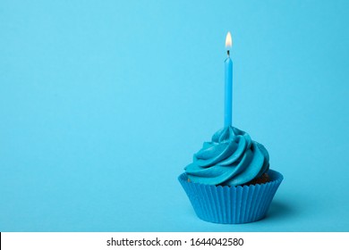 Delicious Birthday Cupcake With Burning Candle On Light Blue Background. Space For Text