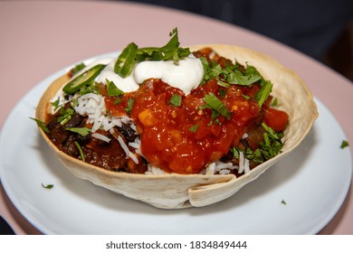 A Delicious Black Bean Burrito Bowl On A Pink Wooden Kitchen Work Top