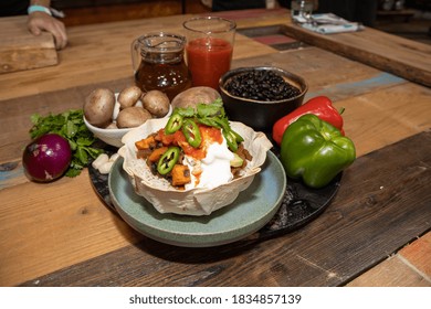 A Delicious Black Bean Burrito Bowl And The  Ingredients Used To Make It On A Wooden Kitchen Work Top