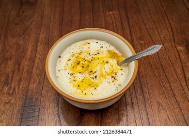 A delicious bowl of grits with melted butter and freshly cracked pepper - Shutterstock ID 2126384471