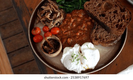 Delicious breakfast in cafe close-up, English breakfast, poached egg, tomatoes and beans - Powered by Shutterstock