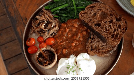 Delicious breakfast in cafe close-up, English breakfast, poached egg, tomatoes and beans - Powered by Shutterstock