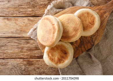 For a delicious breakfast, English muffins buns close-up on a wooden board on the table. horizontal top view from above
 - Powered by Shutterstock