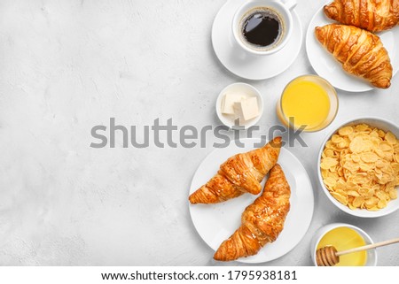 Delicious breakfast with fresh croissants and black coffee on white background. Top view. Copy space.
