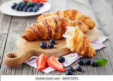 Delicious breakfast with fresh croissants and ripe berries on old wooden background, selective focus - Powered by Shutterstock