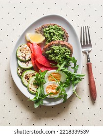 Delicious Breakfast, Snack - Boiled Egg, Smoked Salmon, Grilled Zucchini, Avocado Toast On A Light Background, Top View