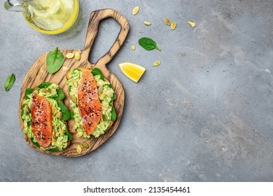 Delicious Breakfast Or Snack Sandwich Salmon, Avocado, Spinach, Nuts, Sunflower Seeds, Toast With Red Fish And Guacamole. Healthy, Clean Eating. Vegan Or Gluten Free Diet. Top View, Copy Space.