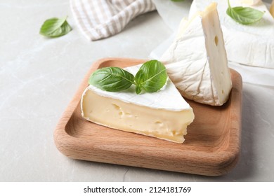 Delicious brie cheese with basil on light grey table - Powered by Shutterstock