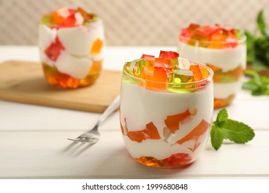 Delicious broken glass jelly dessert on white wooden table, space for text