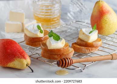 Delicious Bruschetta With Caramelized Pear, Camembert Or Brie Cheese, Honey And Mint. Fruit Dessert. Bread Toast, Crostini. Healthy Breakfast For Gourmets. Selective Focus, Copy Space
