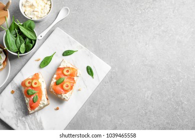 Delicious bruschettas with salmon and olives on marble board