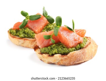 Delicious bruschettas with salmon, pesto sauce and microgreens on white background