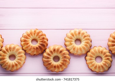 Delicious Bundt Cakes On Pink Wooden Table