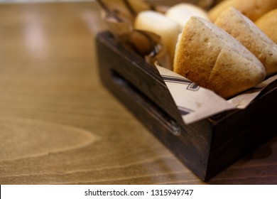 Delicious buns in a wooden basket on a wooden table - Shutterstock ID 1315949747