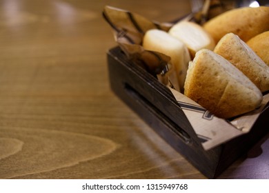 Delicious buns in a wooden basket on a wooden table - Shutterstock ID 1315949768