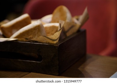 Delicious buns in a wooden basket on a wooden table - Shutterstock ID 1315949777