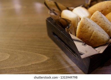 Delicious buns in a wooden basket on a wooden table - Shutterstock ID 1315949798