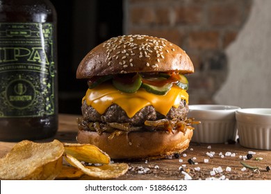 Delicious Burger With Cheddar Cheese And Cucumber Relish On A Rustic Wooden Table