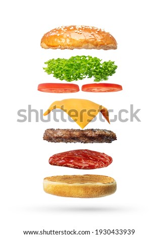 Delicious burger with flying ingredients isolated on white