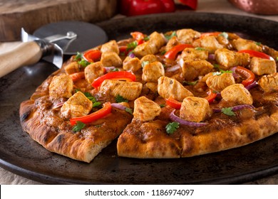 A Delicious Butter Chicken Pizza With Red Pepper, Red Onion And Cilantro.