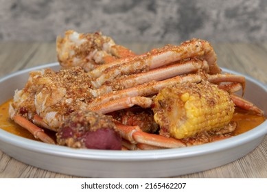 Delicious Buttery Seasoned Snow Crab Legs With Corn On The Cob For A Great Seafood Boil.