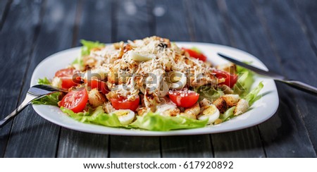 Delicious Caesar salad with cherry tomatoes and Parmesan on a beautiful wooden background