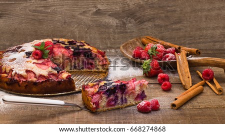 delicious cake with red fruits stuffing over wooden top