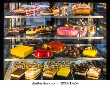 Delicious cakes of different flavors and colors on display in a confectionery shop