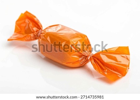 Delicious candy in orange wrapper isolated on white