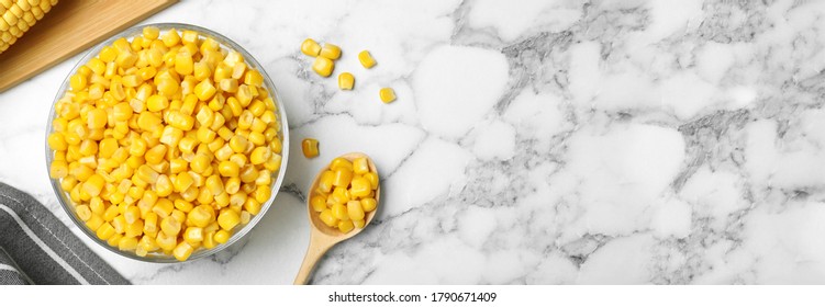 Delicious canned corn in bowl and space for text on marble table, flat lay. Banner design