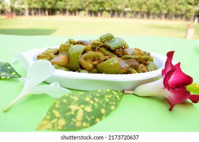 Delicious Capsicum Or Green Bellpepper Curry. Stir Fried With Onions Sauted Indian Asian Sabji With Masala. On Red Background Food Image Copyspace To Write Text. Decorated Shimla Mirch Sabzi