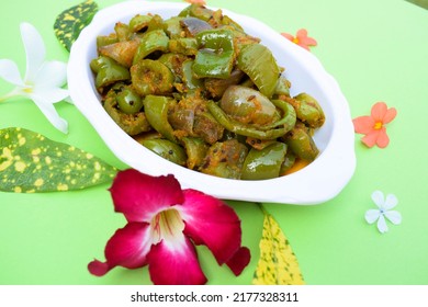 Delicious Capsicum or green bellpepper curry. Stir fried with onions sauted Indian asian sabji with masala. On red background food image copyspace to write text. decorated shimla mirch sabzi