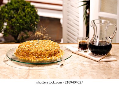 Delicious caramelized nuts cake with sparkler candle, with soda jar and glass, on a balcony background - Powered by Shutterstock