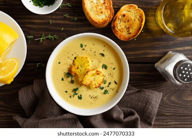 Delicious cauliflower cheese soup in white bowl over wooden background. Vegetarian or healthy diet food concept. Top view, flat lay - Powered by Shutterstock