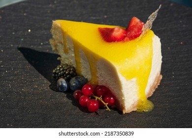 Delicious cheesecake with berries on a black dish in a restaurant - Powered by Shutterstock