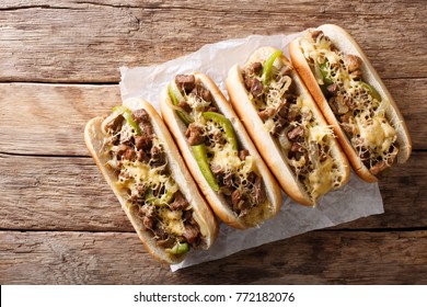 Delicious cheesesteak sandwiches close-up on paper on the table. Horizontal top view from above
