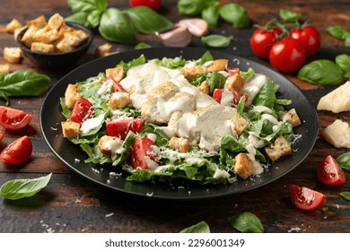 A delicious chicken caesar salad with parmesan cheese, tomatoes, croutons and dressing