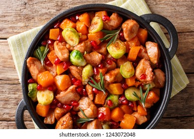 Delicious Chicken Cooked With Vegetables And Rosemary In Pomegranate Sauce Close-up In A Pan On The Table. Horizontal Top View From Above
