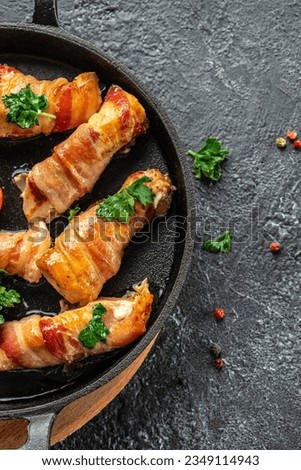 Delicious chicken rolls wrapped in strips of bacon on a cast-iron frying pan. Concept healthy and balanced eating. place for text, top view.