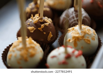 Delicious chocolate bon bon sweets on sticks prepared with Belgian milk chocolate