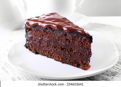 Delicious chocolate cake on plate on table on light background - Shutterstock ID 234653641