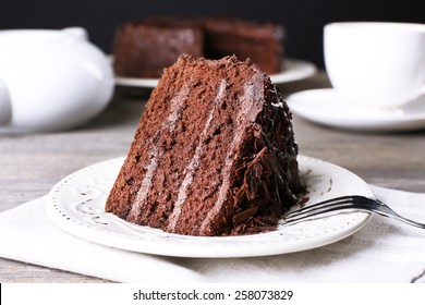 Delicious chocolate cake in white plate on wooden table background, closeup - Shutterstock ID 258073829