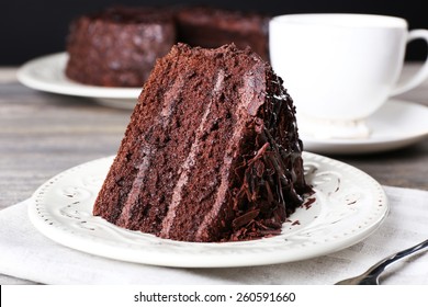 Delicious chocolate cake in white plate on wooden table background, closeup - Shutterstock ID 260591660