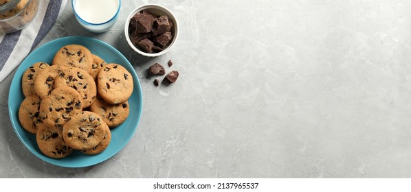 Delicious chocolate chip cookies and glass of milk on grey marble table, flat lay with space for text. Banner design - Powered by Shutterstock