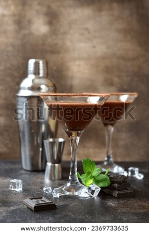 Delicious chocolate coffee martini with mint in a glasses on a dark slate, stone or concrete background.