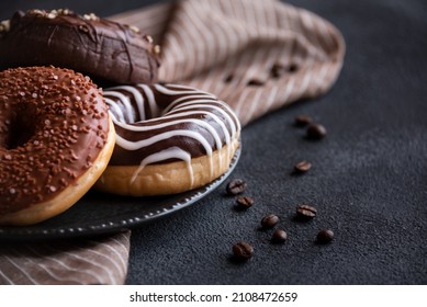 Delicious chocolate donuts with coffee beans on dark background - Powered by Shutterstock