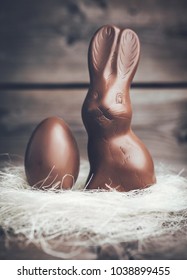 Delicious chocolate Easter bunny and egg on wooden background