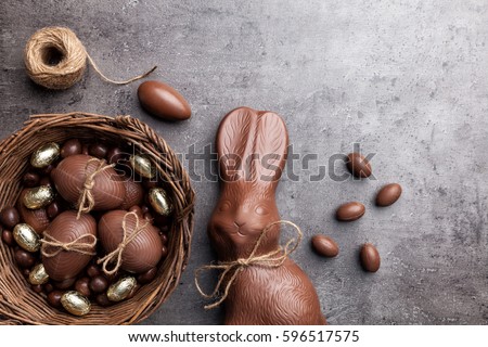Delicious chocolate Easter bunny and eggs on wooden background