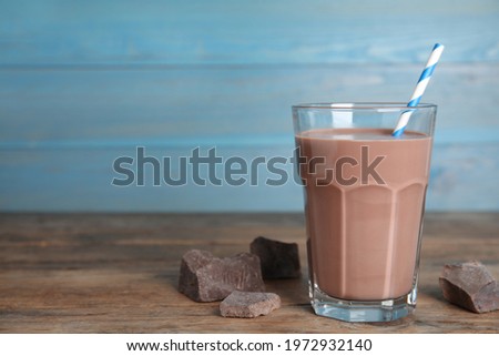 Delicious chocolate milk on wooden table. Space for text